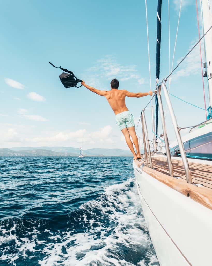 Man with backpack on sailboat